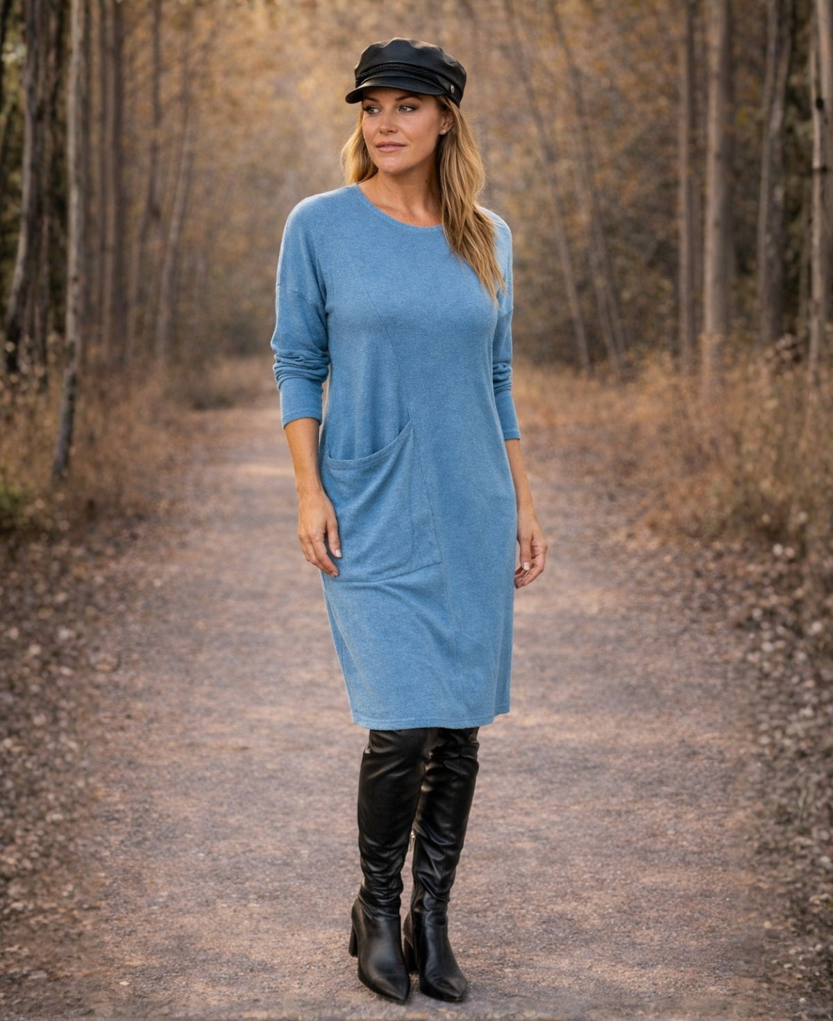 Alessandra teal blue knit dress showing the oversized side pocket and soft drape, worn by a blonde model outdoors