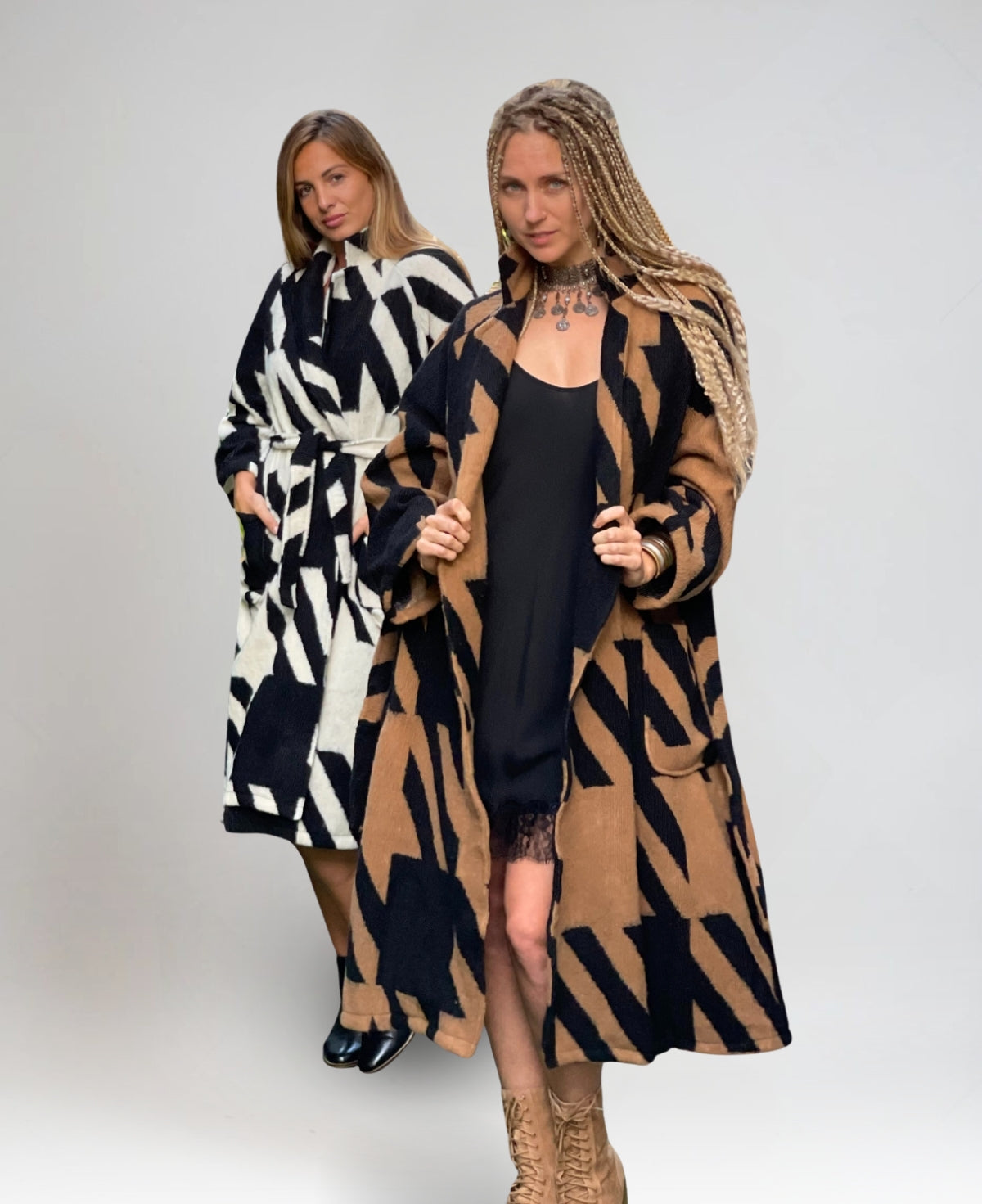 Stylish duo featuring the Cabana Wrap Coat in contrasting white and camel, highlighting its bold black stripe detailing and effortless elegance.