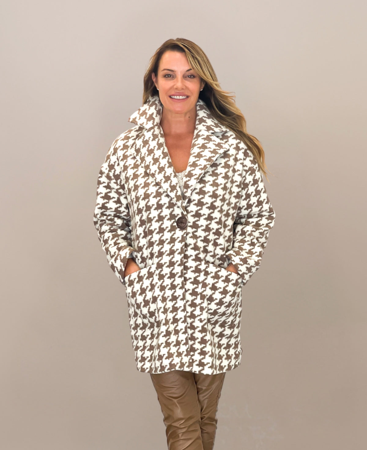 Cream mid-length houndstooth-patterned coat featuring a timeless design, fully lined for extra warmth, perfect for elevating any outfit with its refined and versatile style.