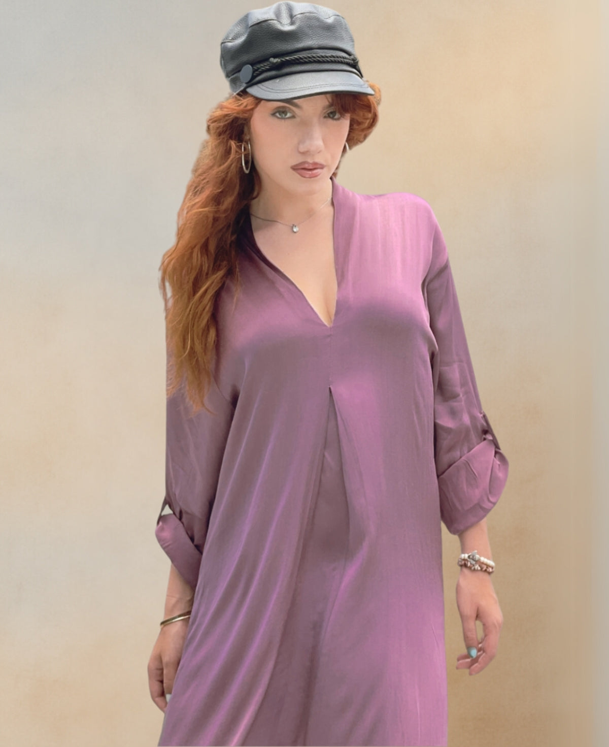 Close-up view of the Valene Maxi Dress in dusty pink, crafted from luxurious satin with a soft sheen. Features a graceful V-neckline, flowing silhouette, and side splits for elegant movement.