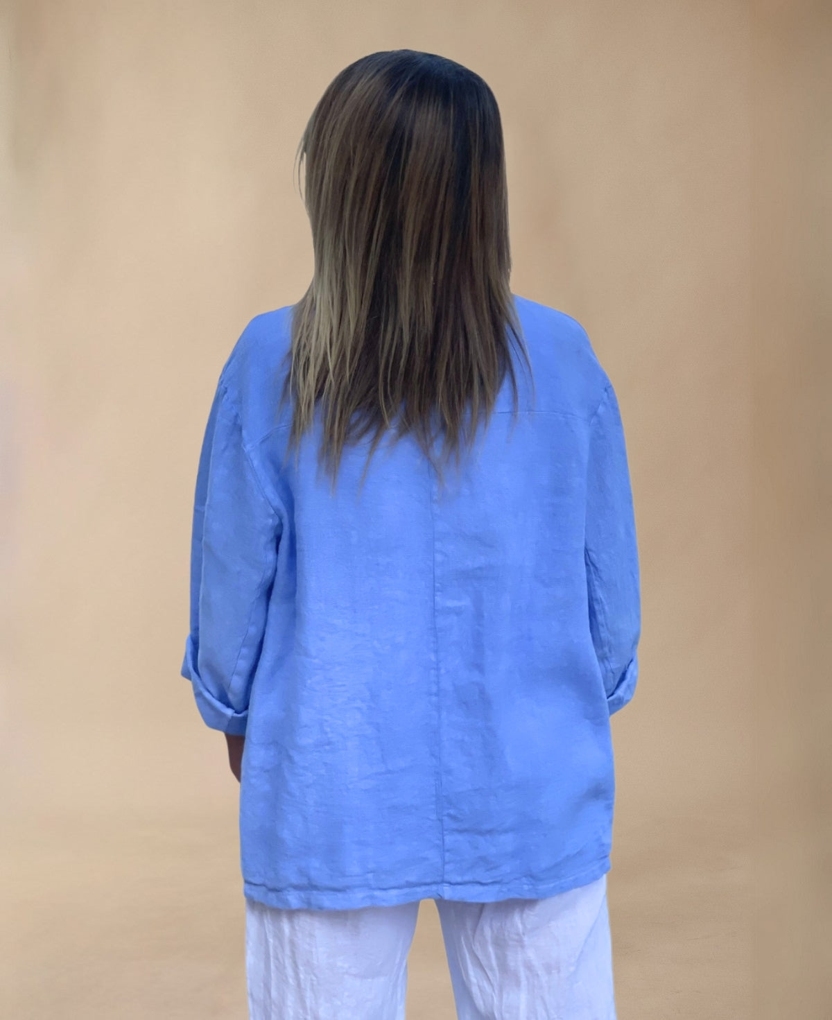 Iris blue linen blazer crafted from lightweight fabric, featuring a relaxed fit, double-button closure, and practical pockets for a refined summer look.