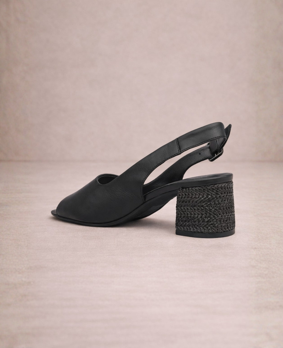 Black slingback heel with textured woven block heel and adjustable strap, shown from back angle