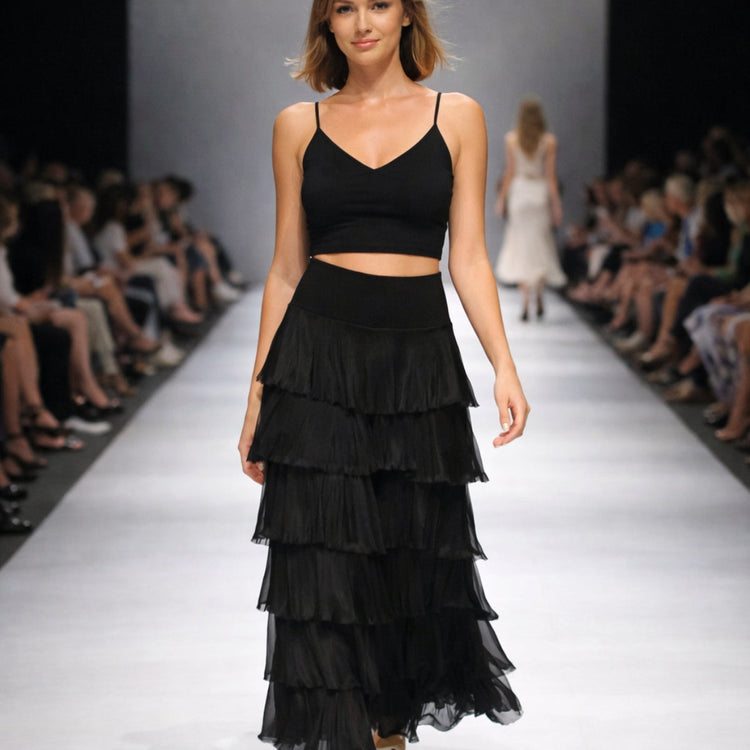 Model walking on a runway wearing a black tiered skirt from designer sample collection showcasing exclusive limited style