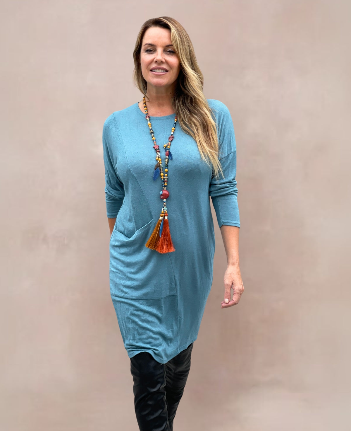 Chic and comfortable teal knit dress featuring a loose silhouette and stylish pocket detail.