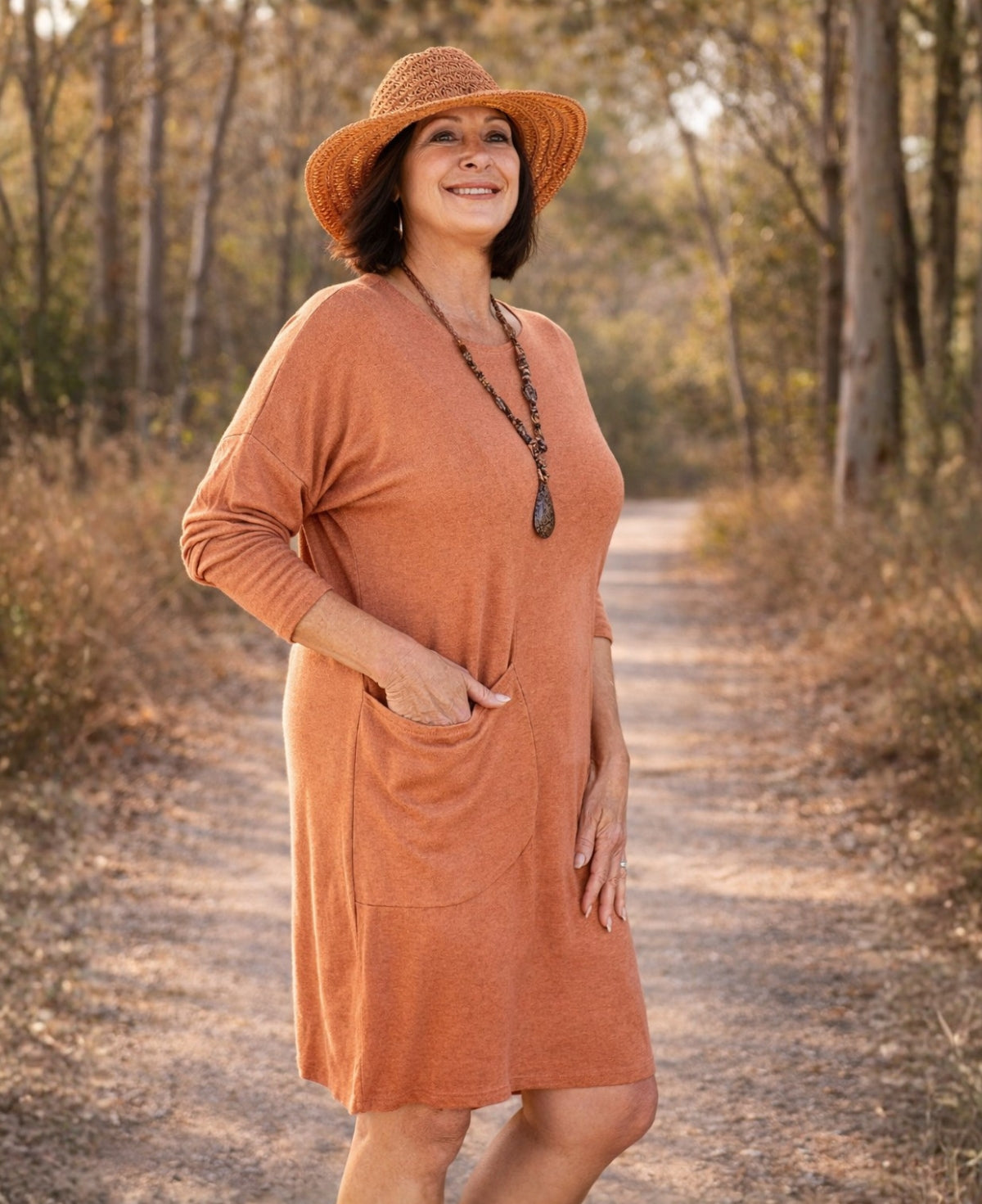 Plus-size model wearing the Alessandra rust knit dress with relaxed silhouette and side pocket
