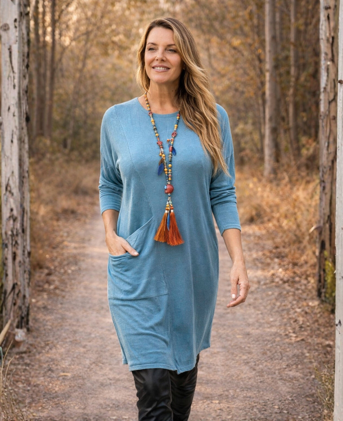 Alessandra blue teal knit dress showing the oversized side pocket and soft drape, worn by a blonde model outdoors