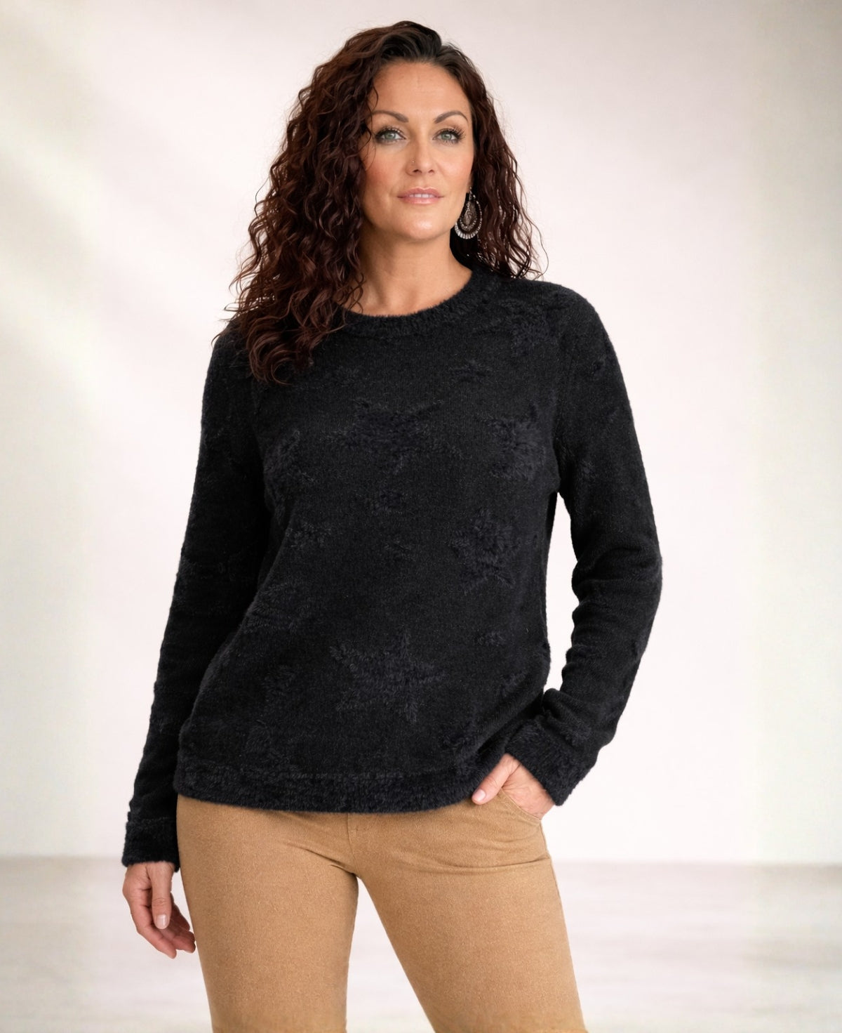 Black viscose blend sweater with subtle star pattern, front view on model in studio lighting