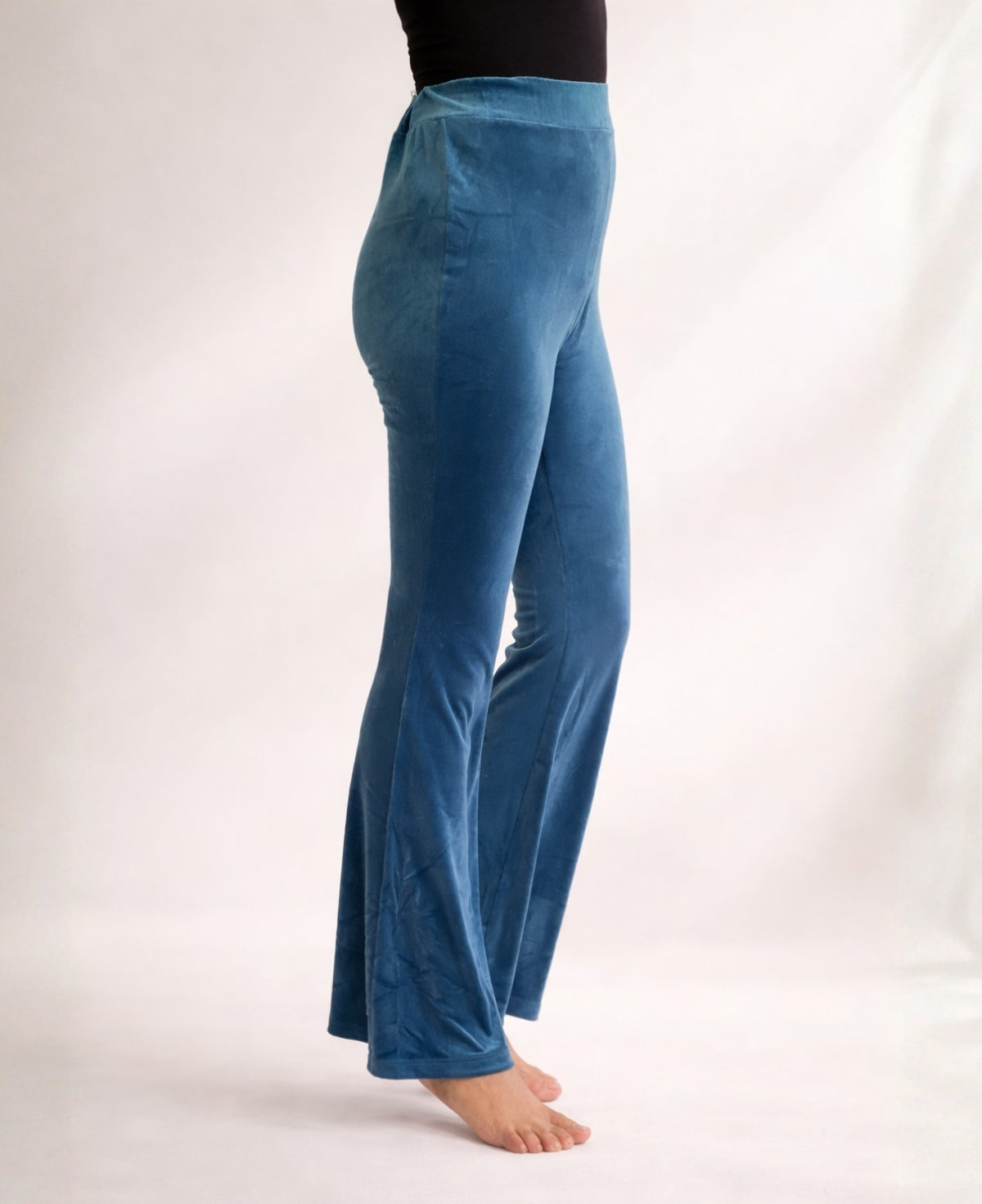 Close-up side view of Blue Teal Marshmallow Velour flare pants showing soft velour texture, high waist and flared leg in studio lighting