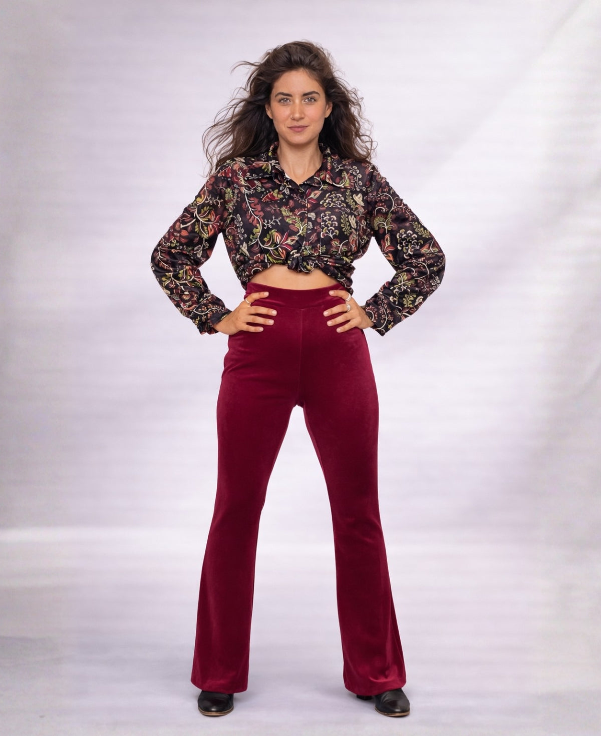 Model wearing Bordeaux Marshmallow Velour flare pants with patterned top, shown in a full body front view against a clean studio background