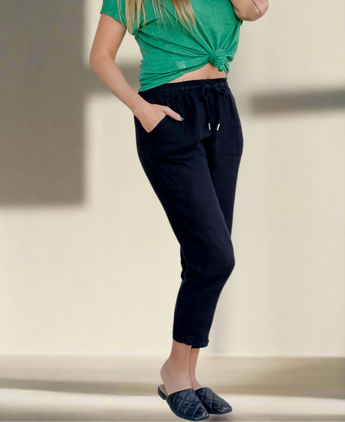Black linen pull-on pants with an elasticated waist, jean-style pockets, and tailored fit, offering a comfortable yet polished look for warm-weather styling.