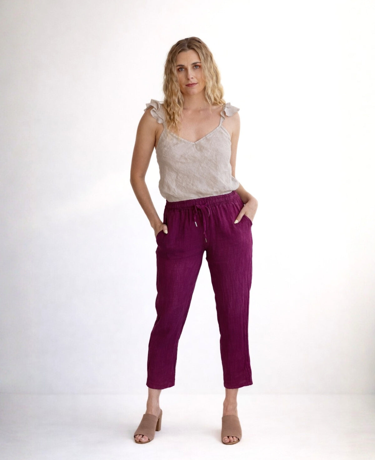 Model wearing Brooklyn linen pants in sangria colour, full body front view with relaxed stance, elastic waist and tapered leg, studio setting Australia