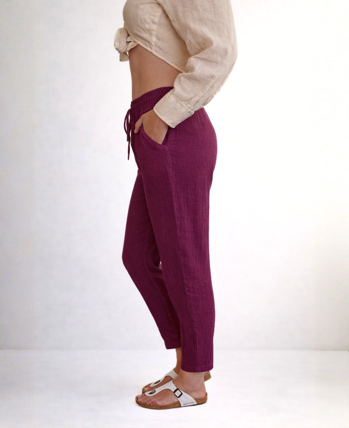 Side view detail of Brooklyn linen pants in sangria showing elastic waistband, side pocket and breathable linen texture, minimalist studio image