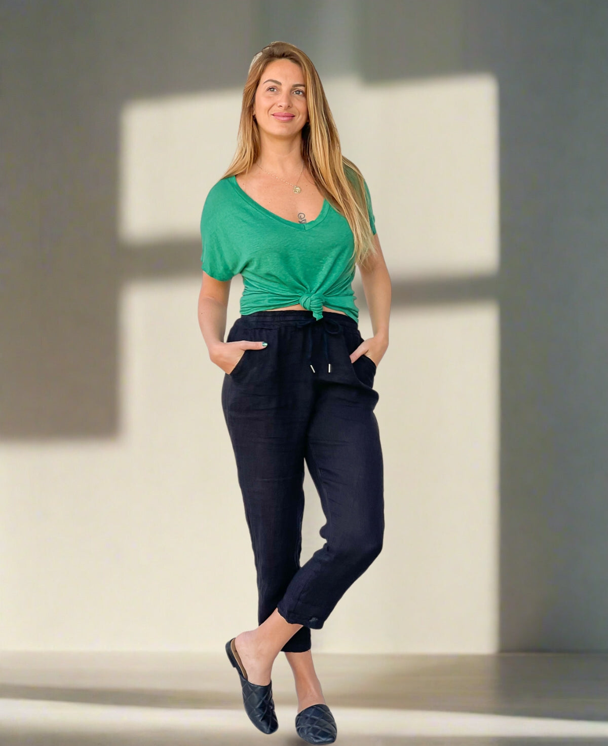 Black linen pull-on pants with an elasticated waist, jean-style pockets, and tailored fit, offering a comfortable yet polished look for warm-weather styling.