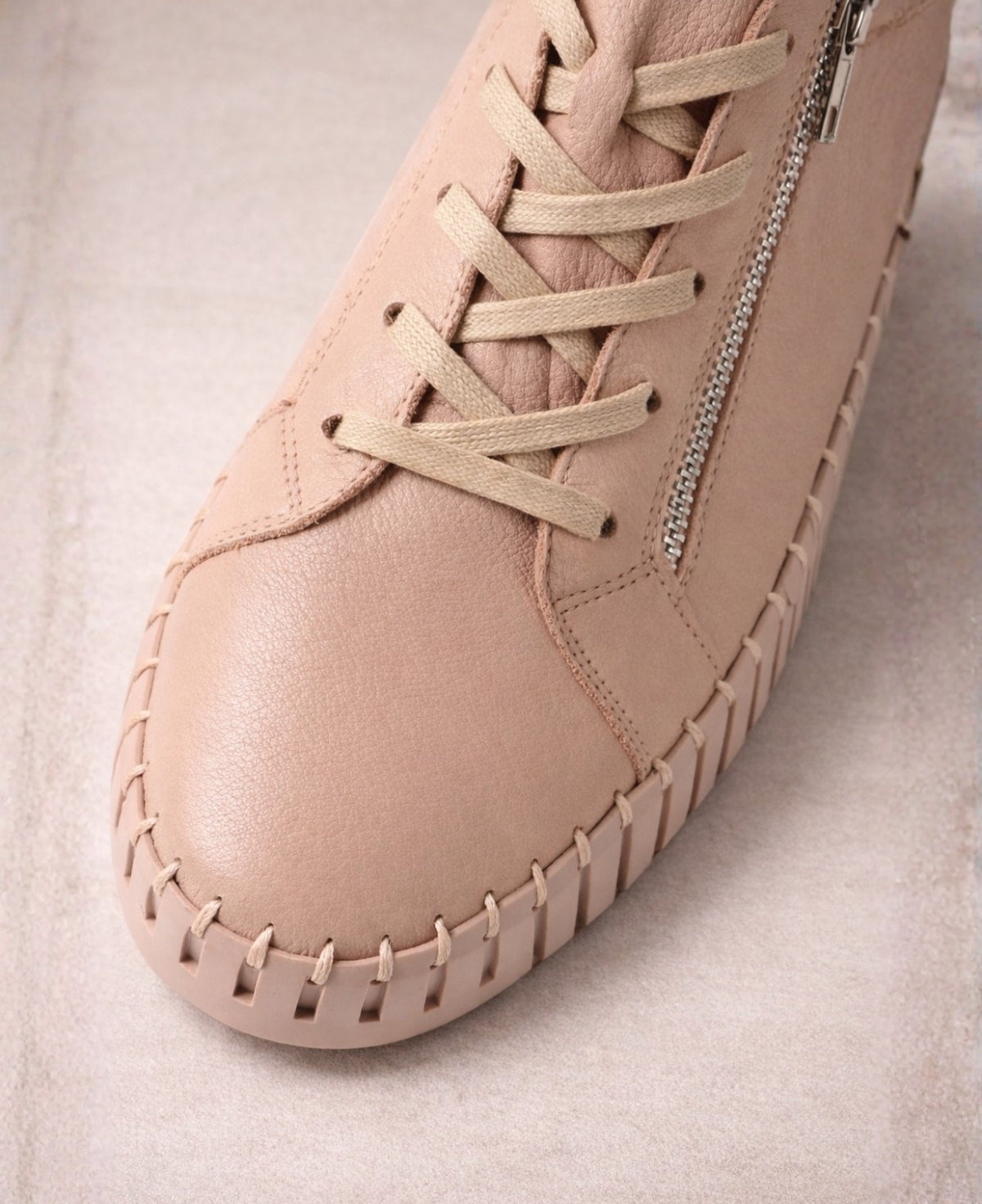 Close-up of Bump Rose Leather Sneakers showing smooth leather texture, lace-up closure, stitching and silver zip detail
