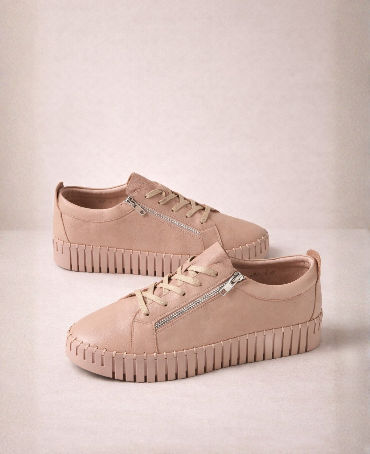 Pair of Bump Rose Leather Sneakers in blush pink leather displaying lace-up design, outer zip entry and elevated platform sole