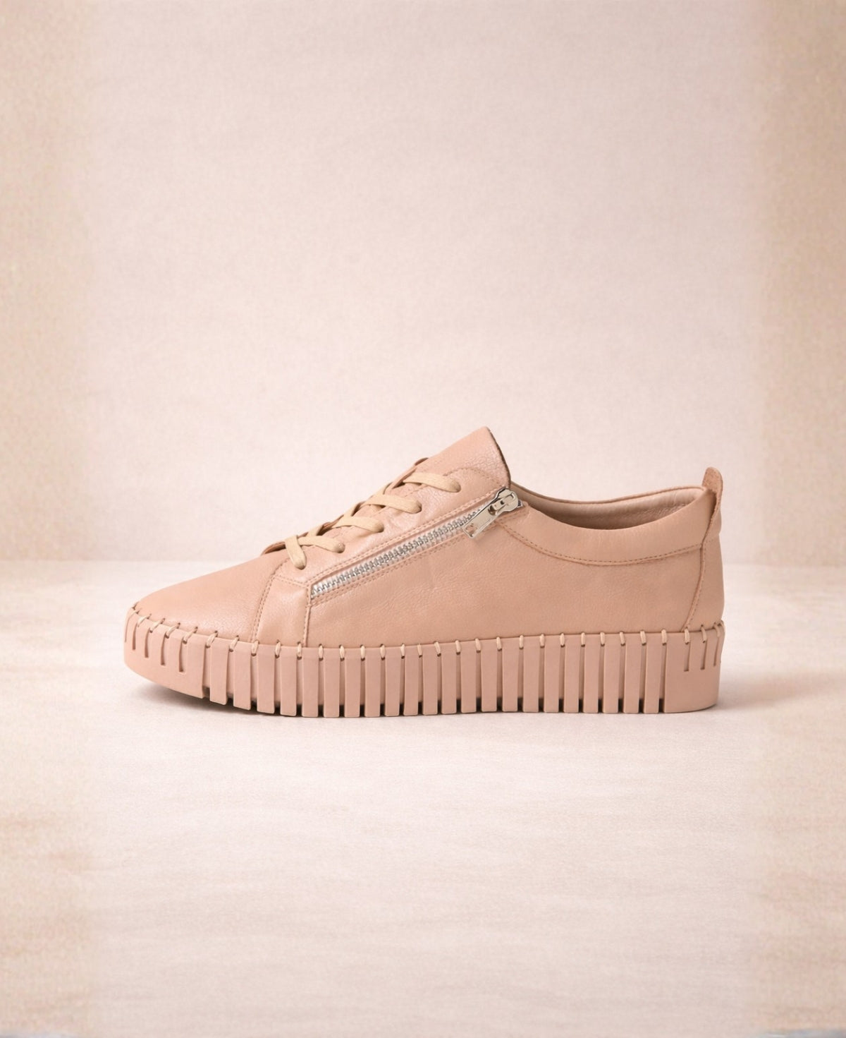 Side view of Bump Rose Leather Sneakers in blush pink leather featuring lace-up front, outer zip detail and 90s-inspired platform cleated sole