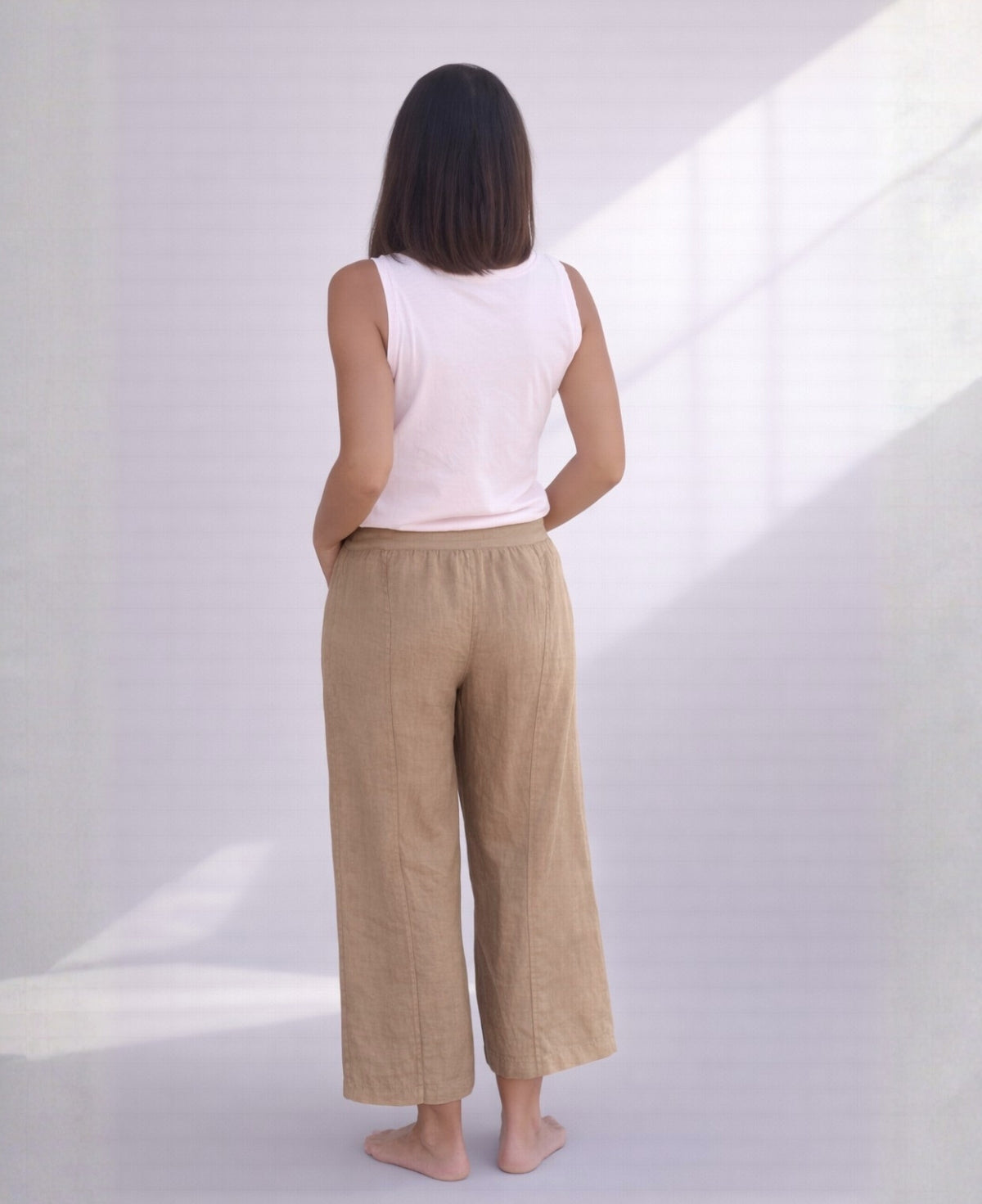 Back view of camel linen palazzo pants showing stretch waistband, clean seams, and natural linen texture.
