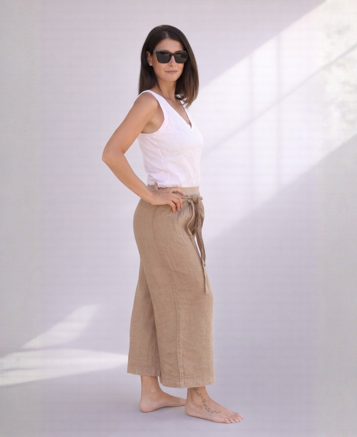 Side view of camel linen palazzo pants highlighting straight leg silhouette, soft drape, and breathable linen fabric.