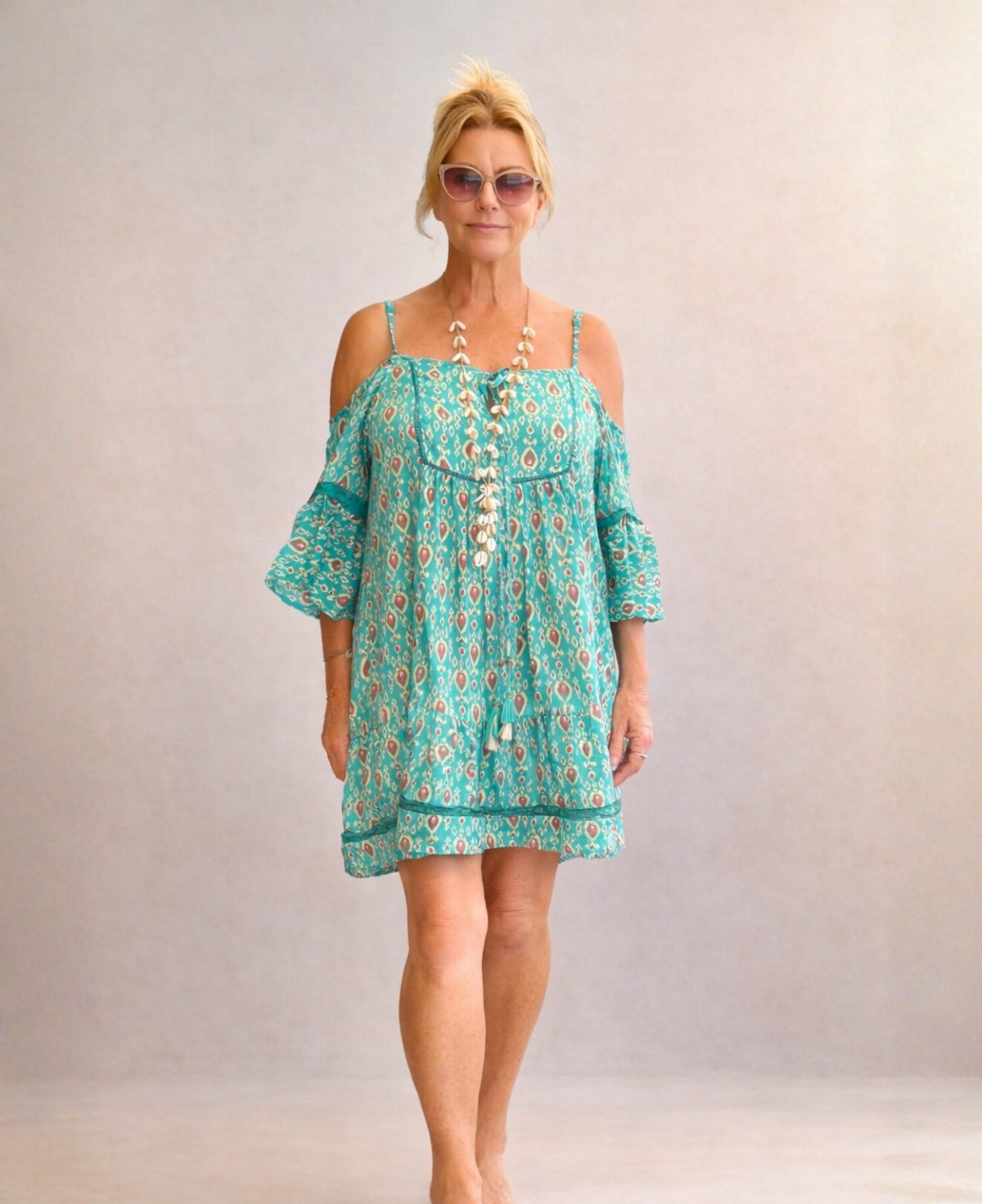 Front view of the Camellia silk dress in teal, featuring a relaxed tiered silhouette, cold shoulder sleeves and Indian silk fabric on a model in a soft studio setting.