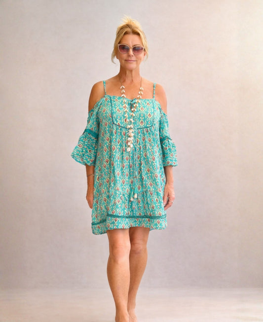 Front view of the Camellia silk dress in teal, featuring a relaxed tiered silhouette, cold shoulder sleeves and Indian silk fabric on a model in a soft studio setting.