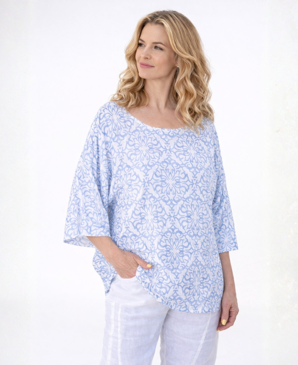 Capri Linen T-shirt in sky blue worn by blonde model, lightweight linen fabric with soft drape, photographed in a studio