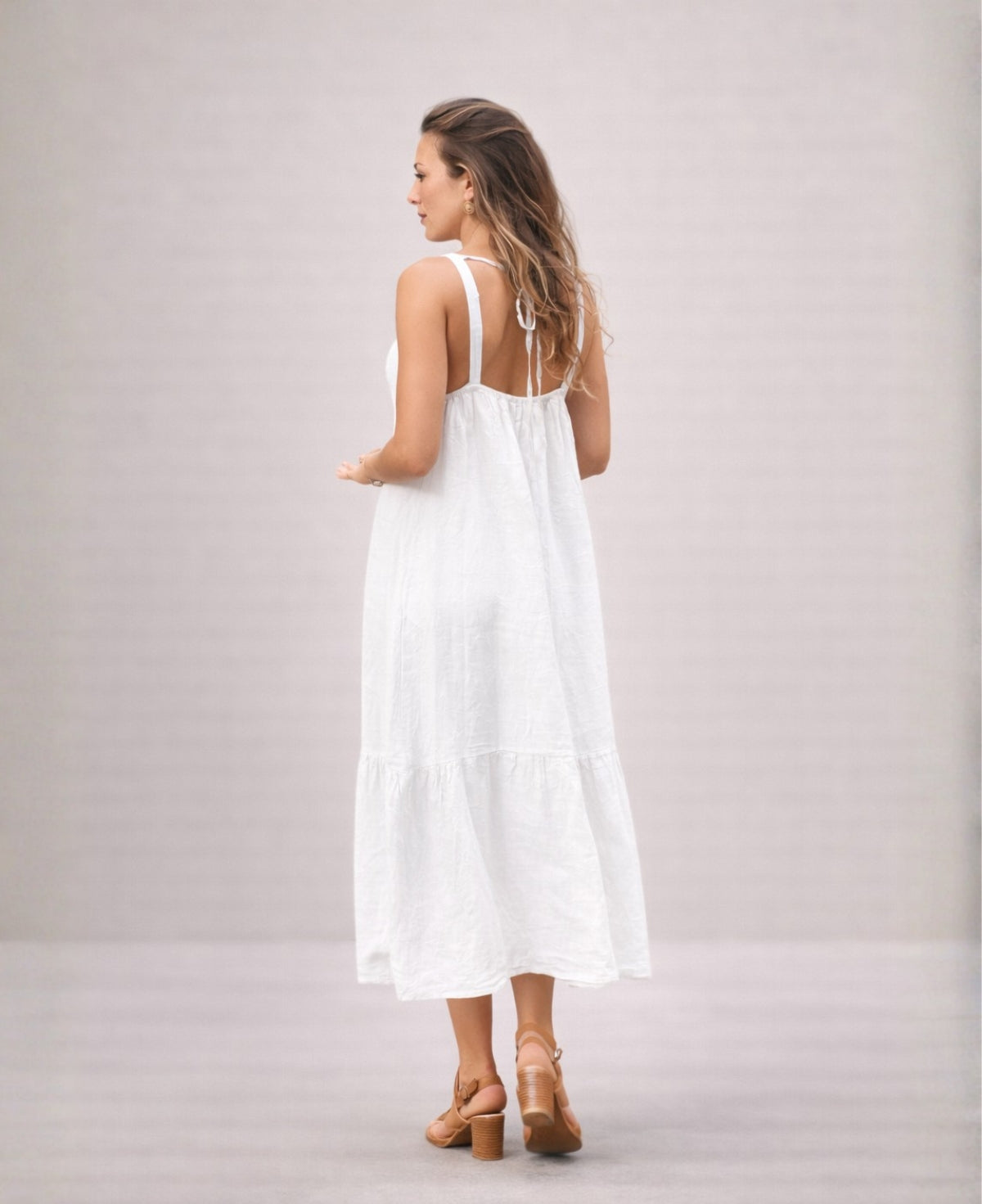 Back view of the Cassey linen dress in white, featuring open back design with adjustable tie and wide shoulder straps.