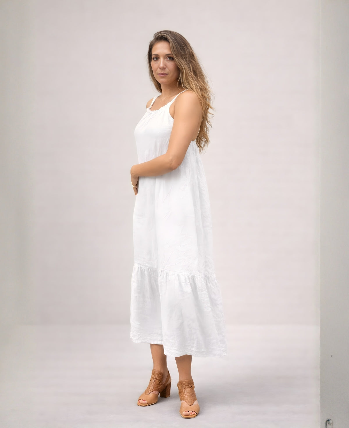 Front angled view of the Cassey linen dress in white, showing airy linen fabric, relaxed silhouette and soft drape.