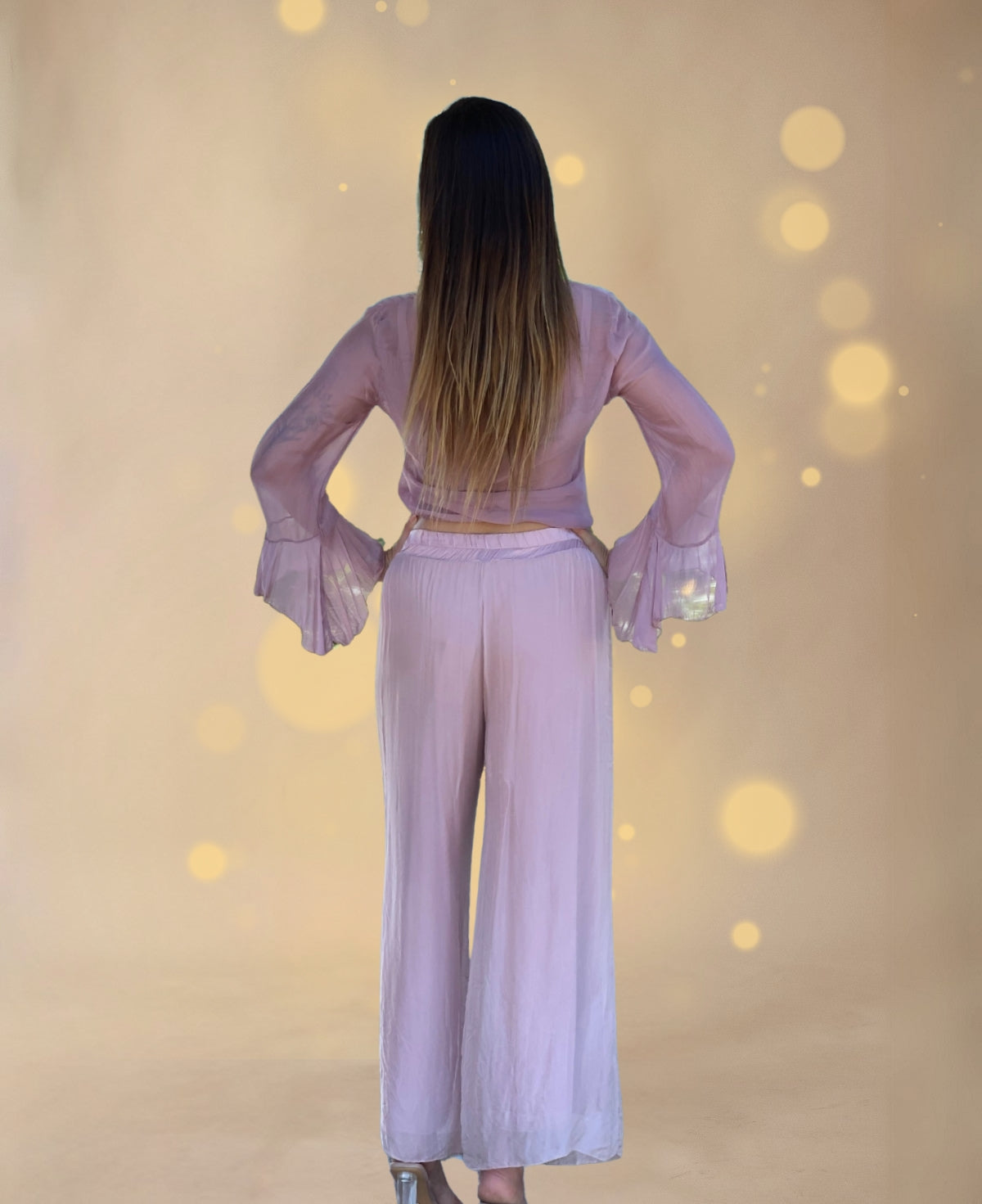 Back view of the Cora pants in a luxurious silk blend, showcasing their effortless drape and comfortable elastic waistband.