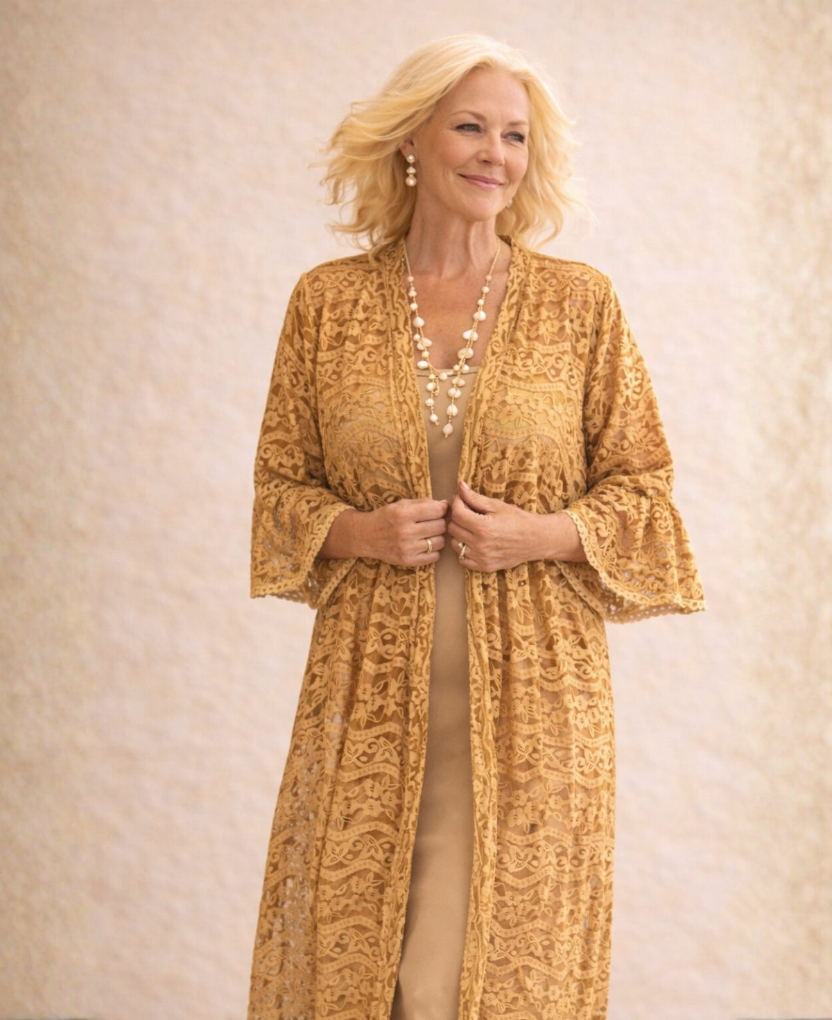 Front detail of the Daniella Lace Kimono in Caramel featuring semi-sheer cotton lace, 3/4 fluted sleeves and open-front design against a warm limestone background.