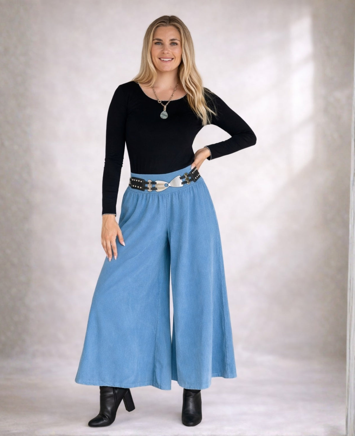 Model wearing Demi Corduroy Pants in Blue Heaven, wide-leg fine ribbed corduroy pants with stretch waist, front view.