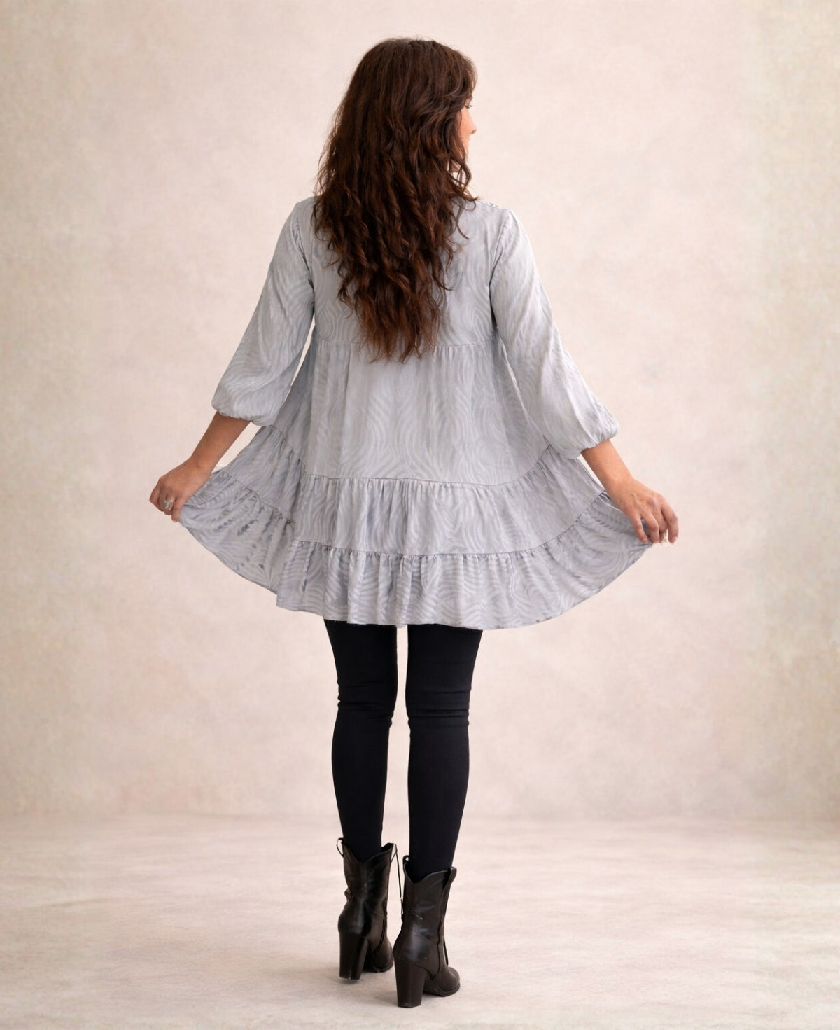 Back view of the silver Eden Pattern satin top mini dress highlighting the flowing tiers and cold silver embossed satin finish.