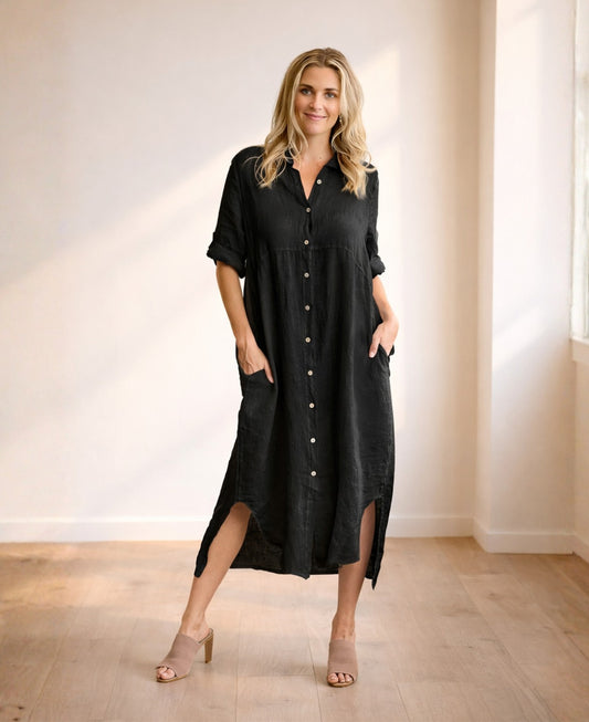 Front view of black linen Empire Jac-Dress with empire waist seam, button front and soft curved hem, styled in warm minimalist studio.