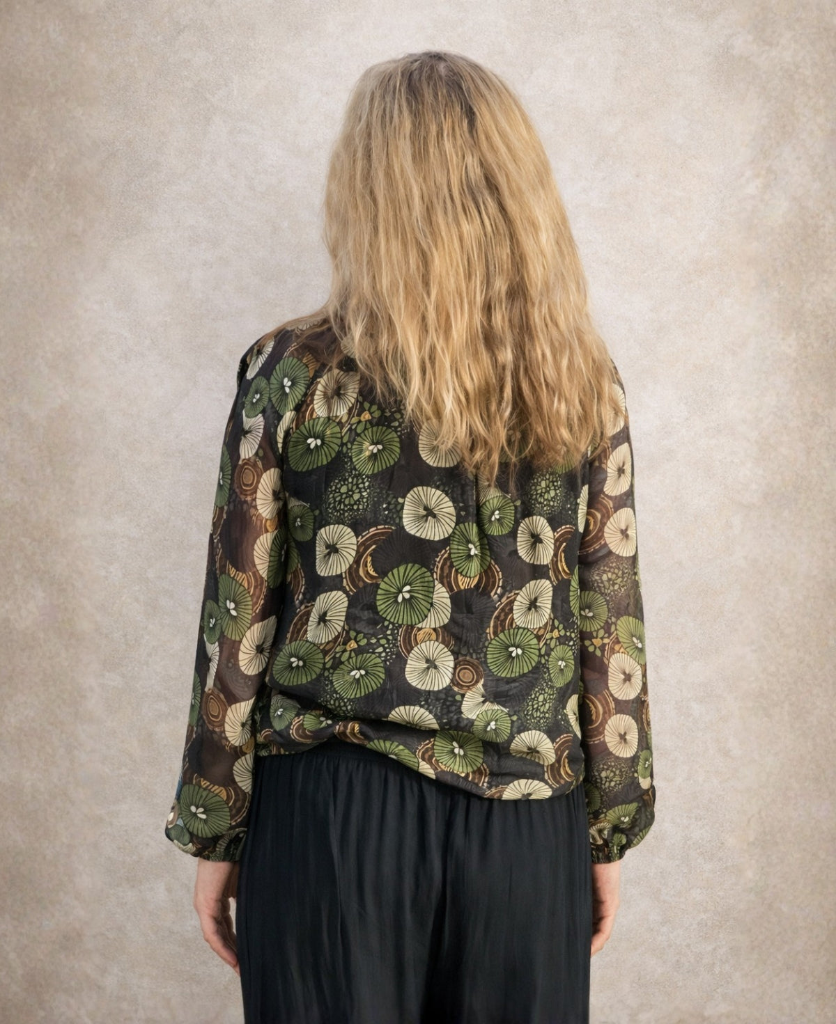 Back view of the Fern Silk Blouse showing sheer silk fabric, botanical green print and flowing relaxed cut