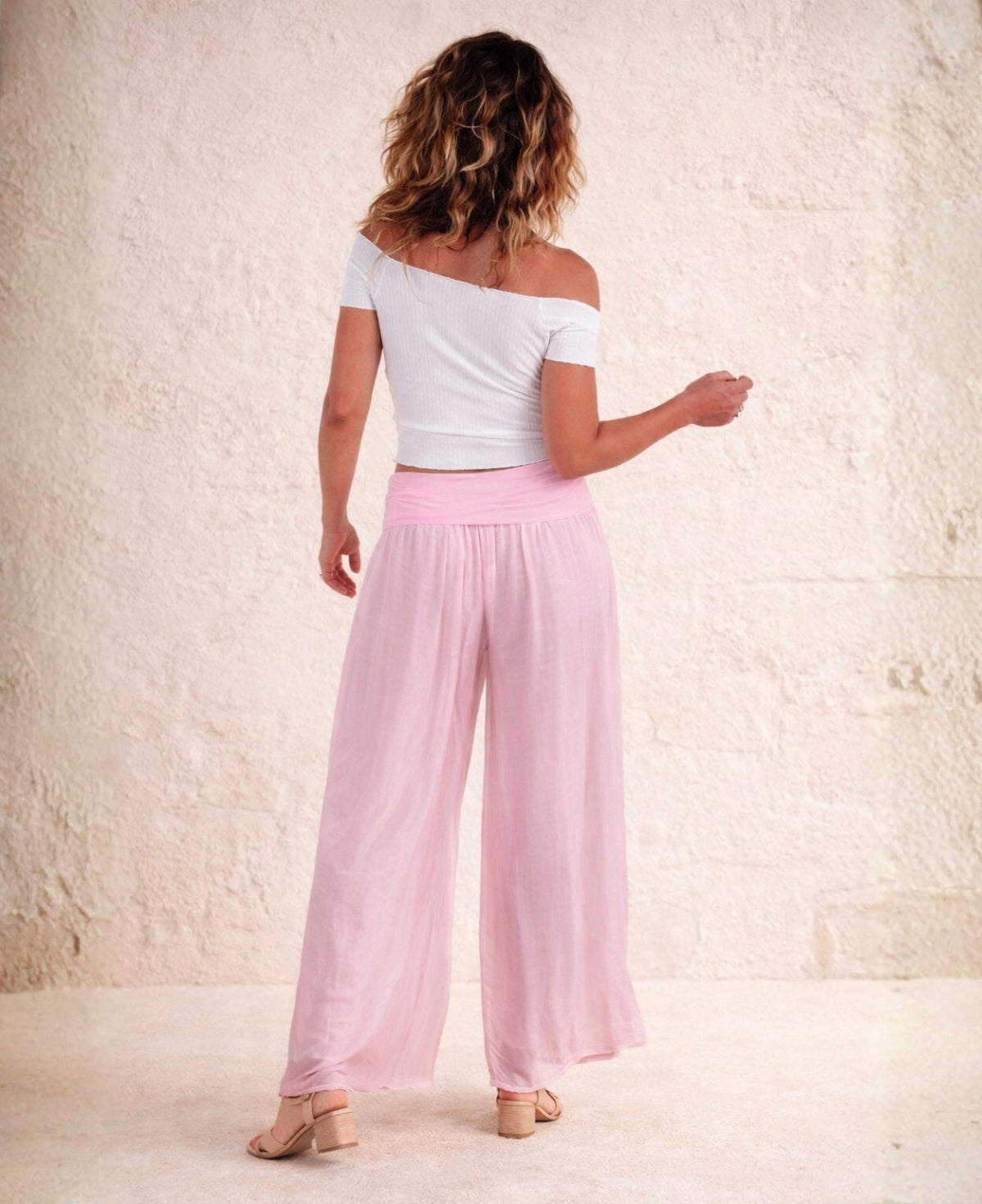 Back view of Fleur Silk Pants in Rose pink, highlighting flowing silk fabric, wide straight leg and visible shorter lining.