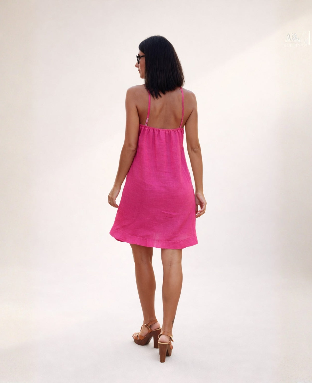 Back view of the Florence Linen Dress in hot pink, showing thin adjustable straps and an easy, flowy linen silhouette.
