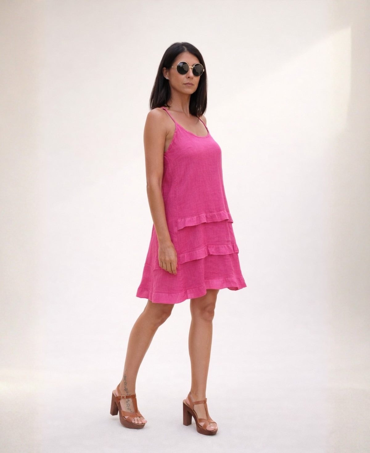 Side view of the Florence Linen Dress in hot pink, highlighting the lightweight linen fabric, tiered skirt and relaxed summer fit.