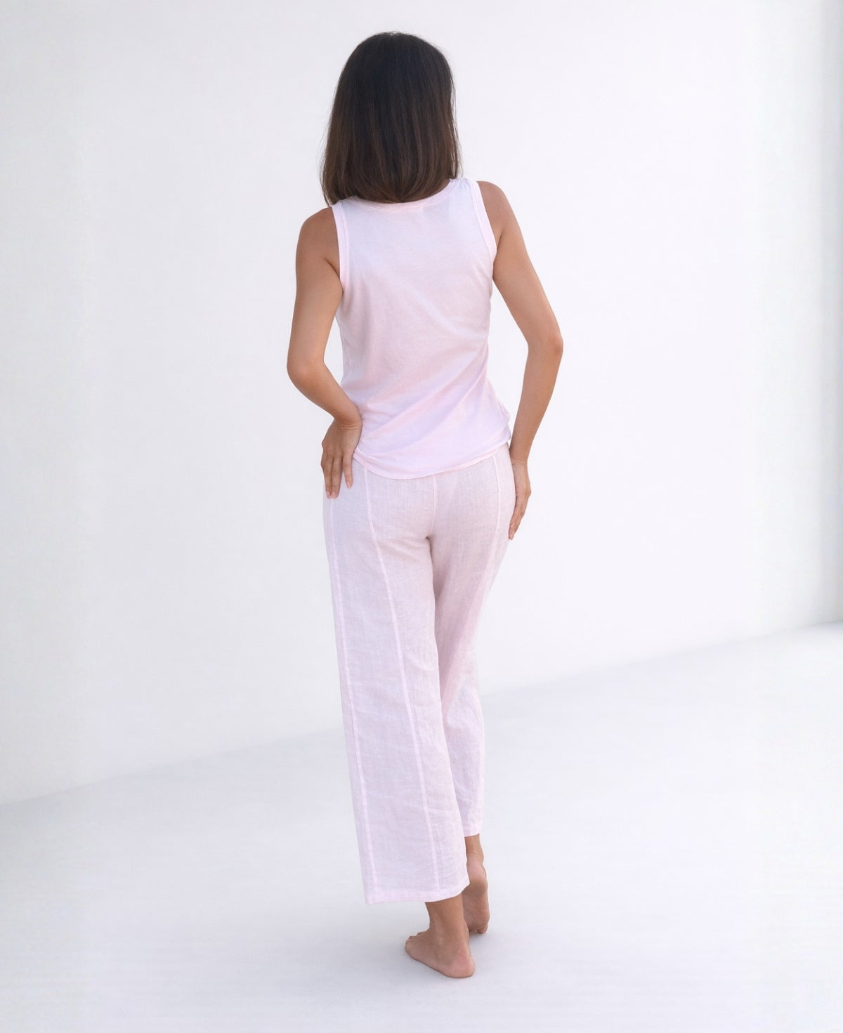Back view of model wearing Florence Linen Palazzo Pants in Blush, showing wide-leg palazzo silhouette, soft linen texture, and relaxed fit through the leg.