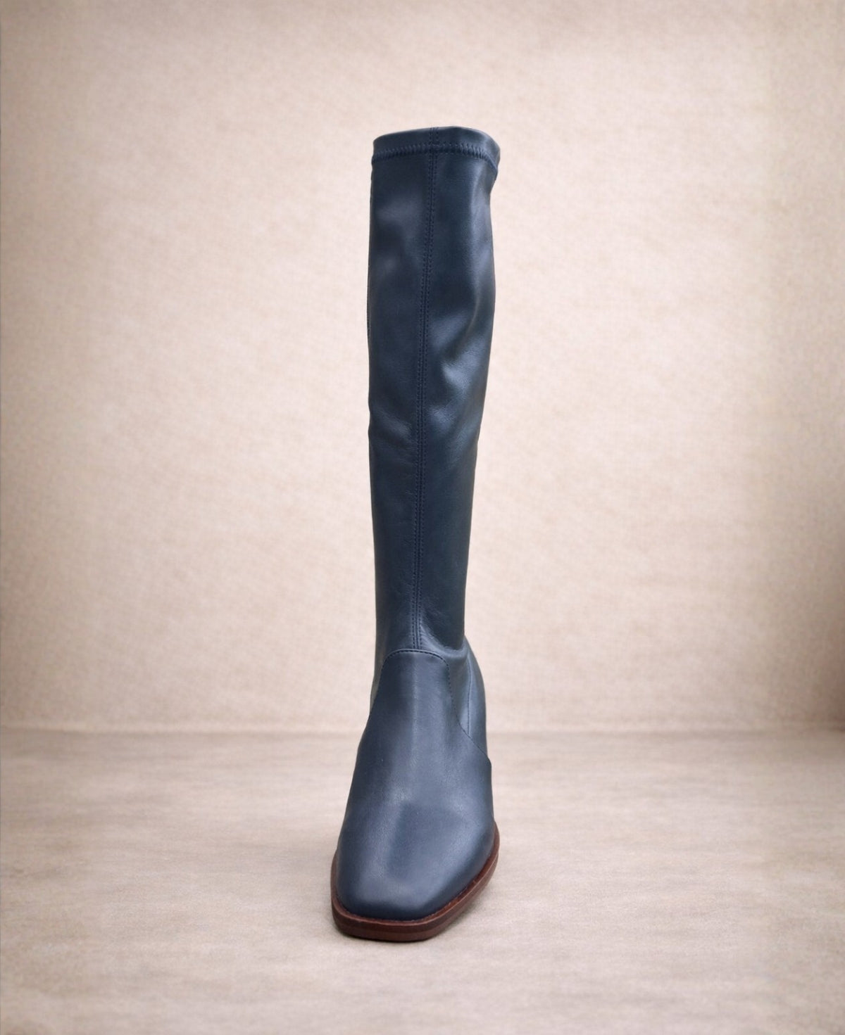 Front view of navy stretch knee-high boot highlighting the square toe and sleek streamlined shape.