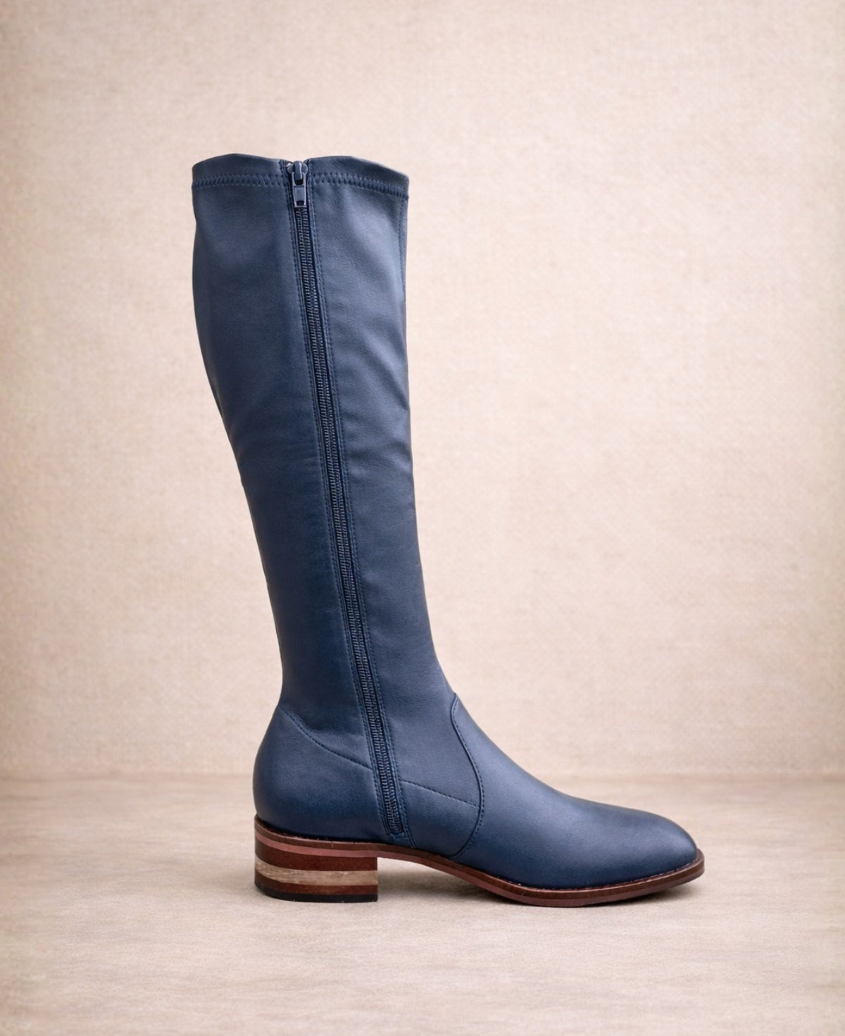 Navy knee-high stretch boot showing inner zip entry, smooth leather finish, and stacked block heel.