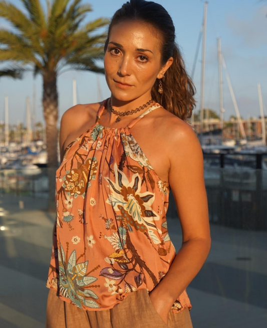 Gardenia halter top in rose gold with a delicate floral print, featuring a flattering low back and tie-up neckline. A chic and versatile summer statement piece.