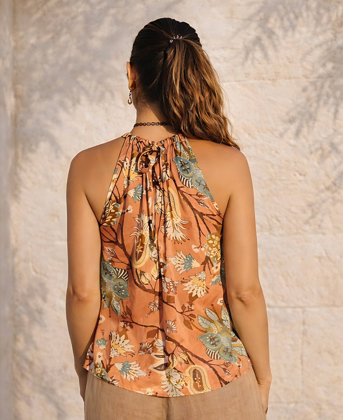 Back view of the Gardenia Satin Top in Gold Rose showing the keyhole opening and tie detail at the neckline with a soft flowing silhouette.