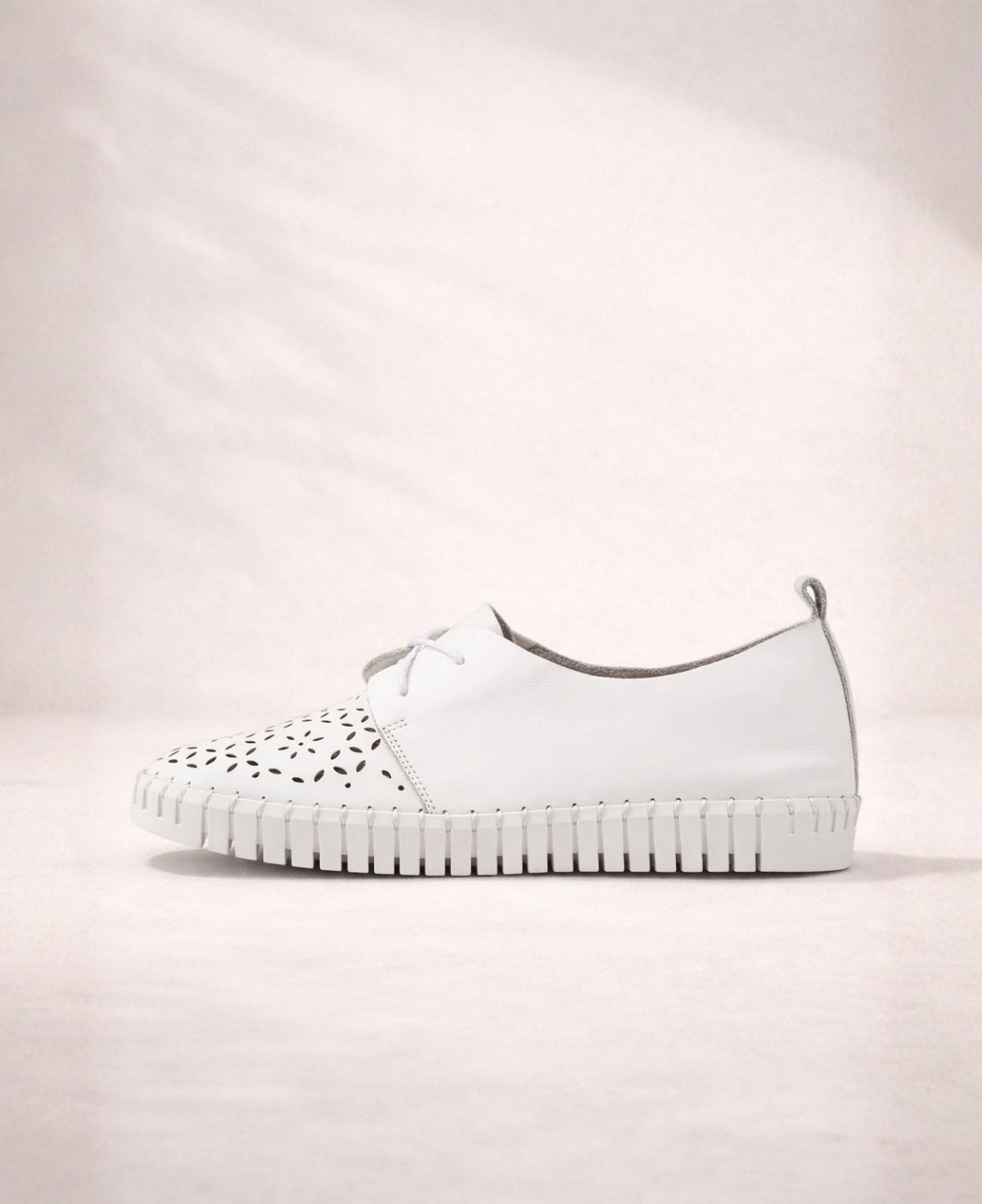 Side profile of Hexter white leather sneakers showing clean silhouette, leather finish, and flexible cleated sole
