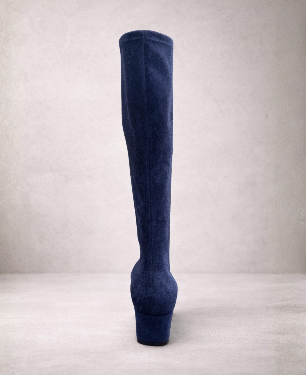 Back view of Hoppey navy suede knee high boots showing the smooth fitted shaft and block heel on a minimalist studio-style background.