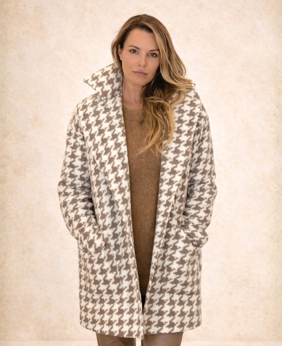 Cream mid-length houndstooth-patterned coat featuring a timeless design, fully lined for extra warmth, perfect for elevating any outfit with its refined and versatile style.