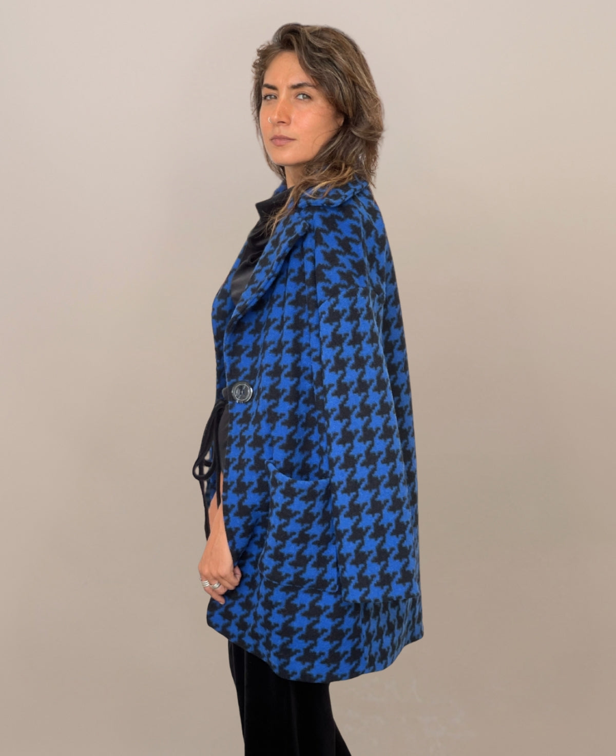 Royal blue mid-length houndstooth-patterned coat, seamlessly blending classic elegance with modern sophistication, fully lined for warmth and a chic alternative to the traditional long overcoat.