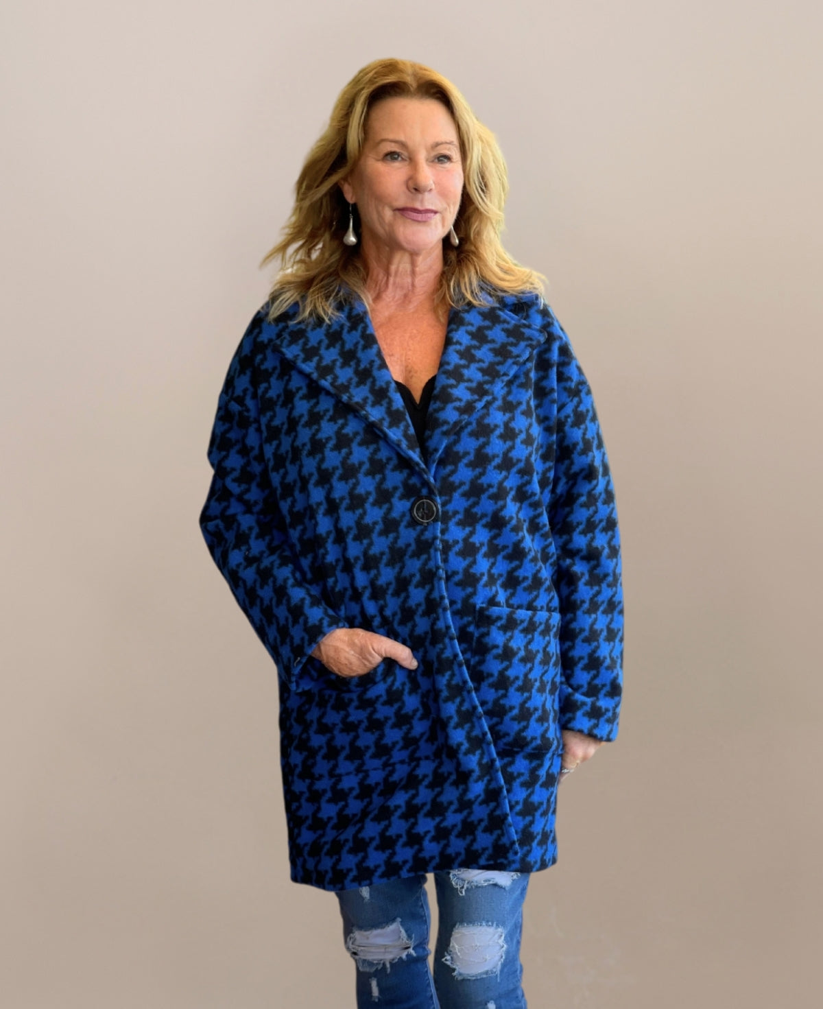 Royal blue mid-length houndstooth-patterned coat, seamlessly blending classic elegance with modern sophistication, fully lined for warmth and a chic alternative to the traditional long overcoat.
