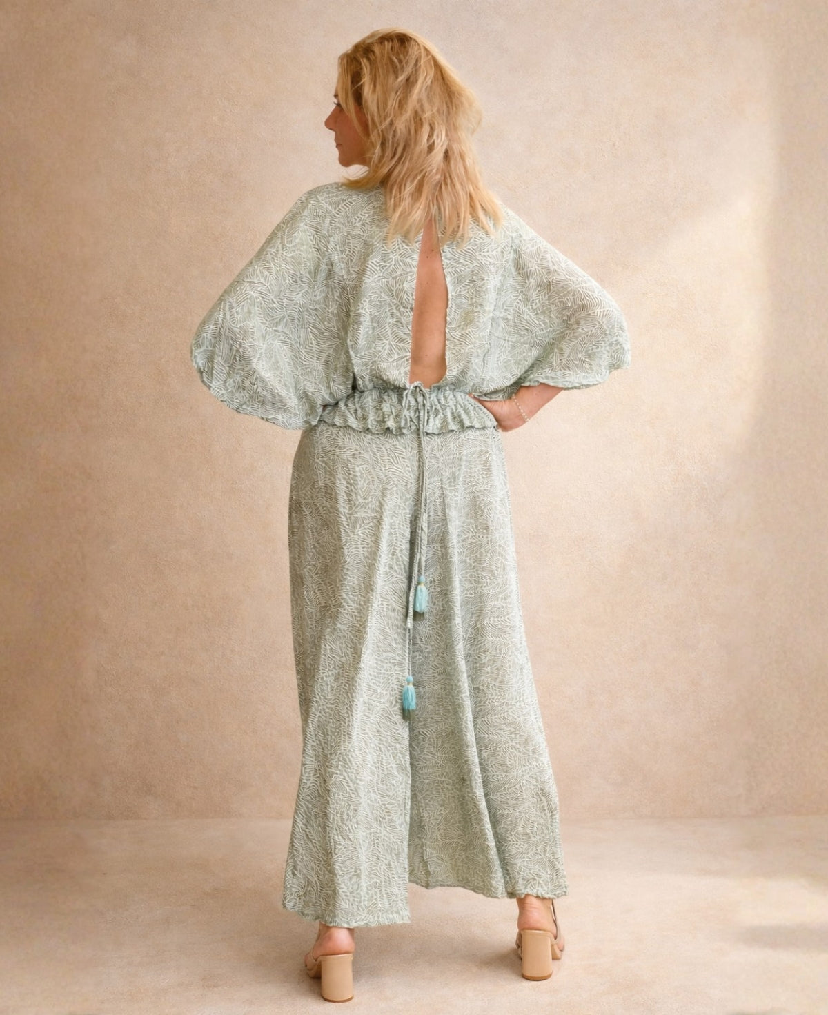 Back view of the Iris Silk Set showing open back silk top with tie detail and flowing wide leg pants in sage green Indian silk blend.