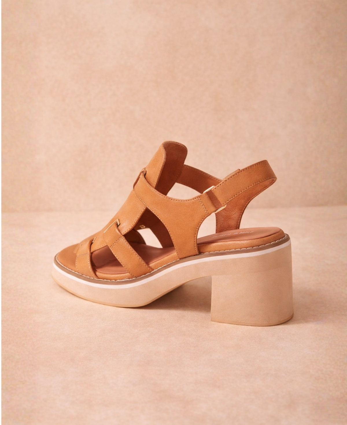 Back three-quarter view of Jennis tan leather sandals showing the heel strap and block heel