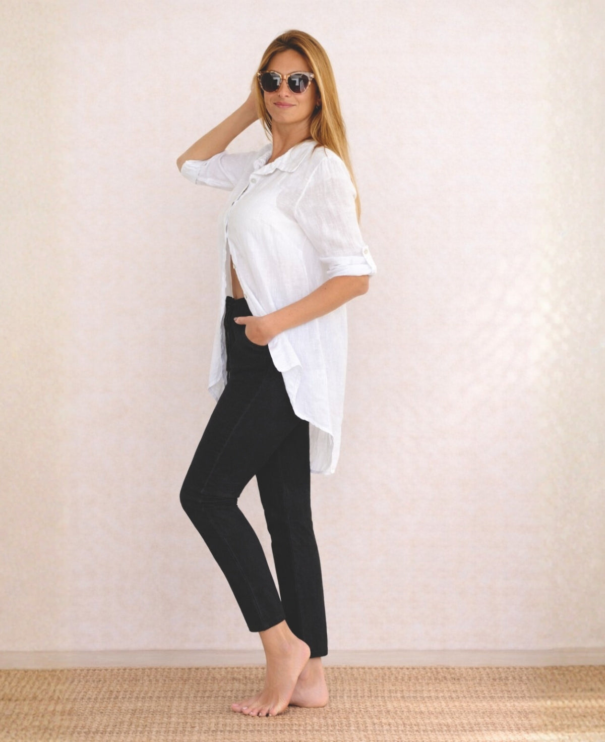 Full body side view of the Jordan Linen Pants in black worn with white linen shirt, highlighting slim leg shape.