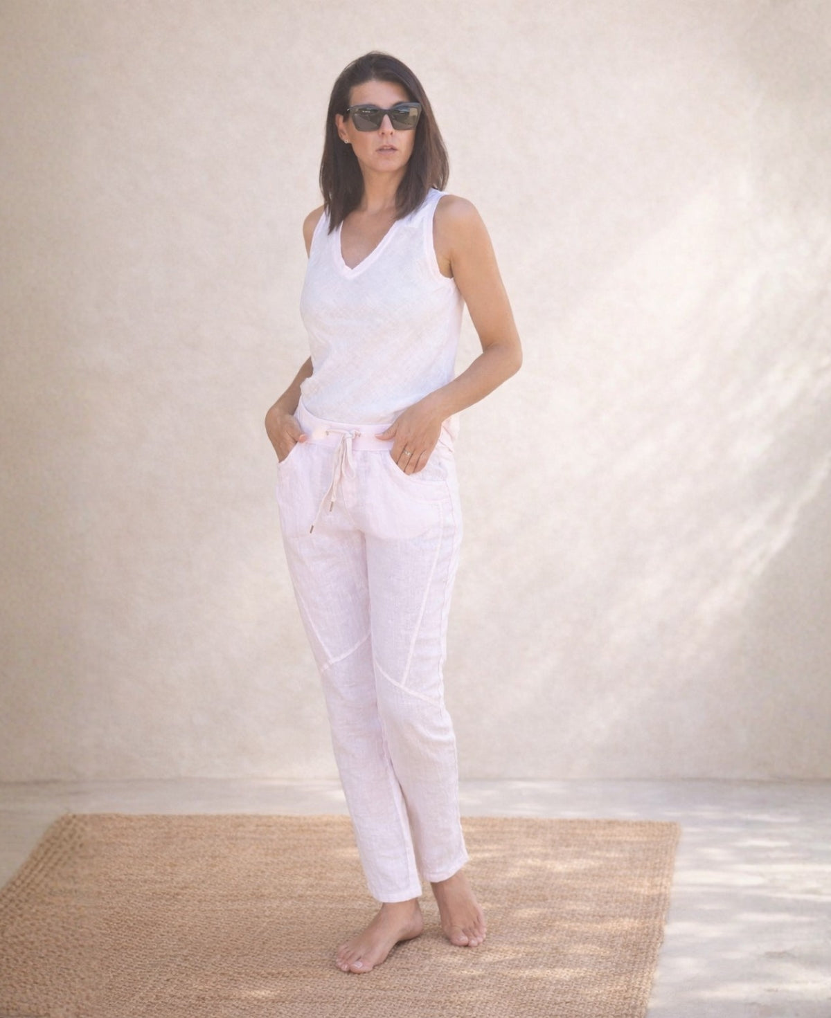 Full body front view of the Jordan Linen Pants in blush with narrow leg silhouette and panel seam detail.